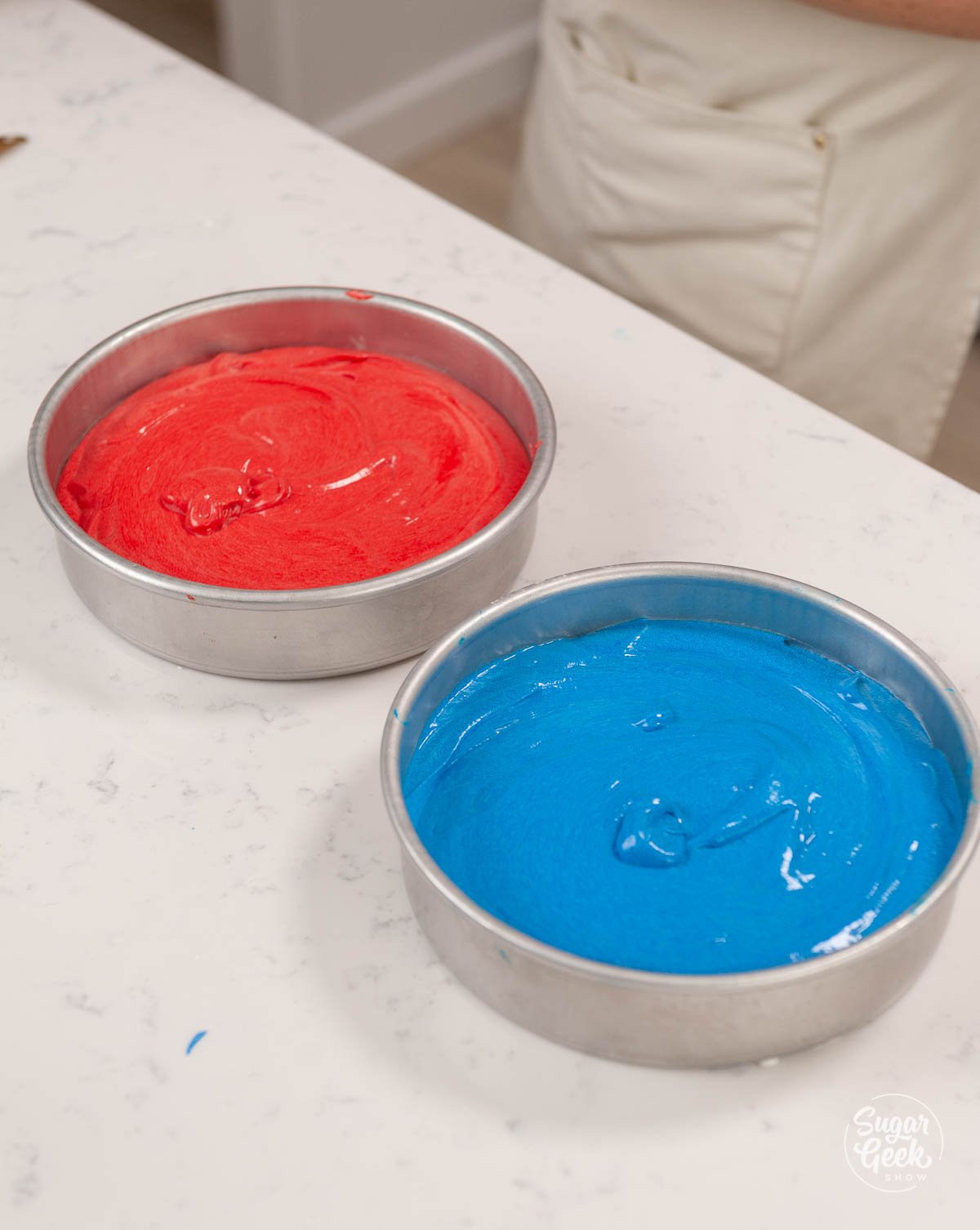 red and blue cake batter in cake pans