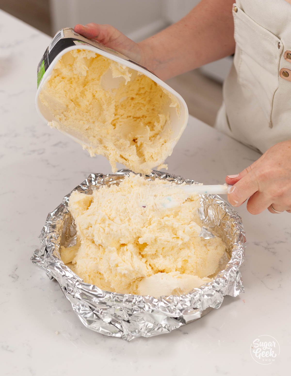 placing softened ice cream into an aluminum foil lined cake pan