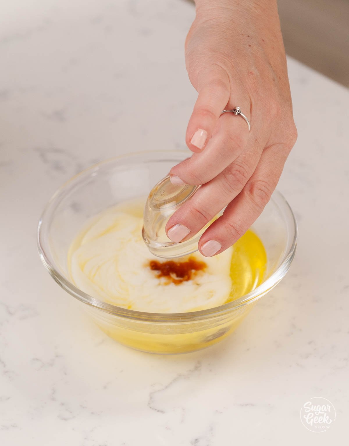 adding vanilla to milk and eggs in a bowl