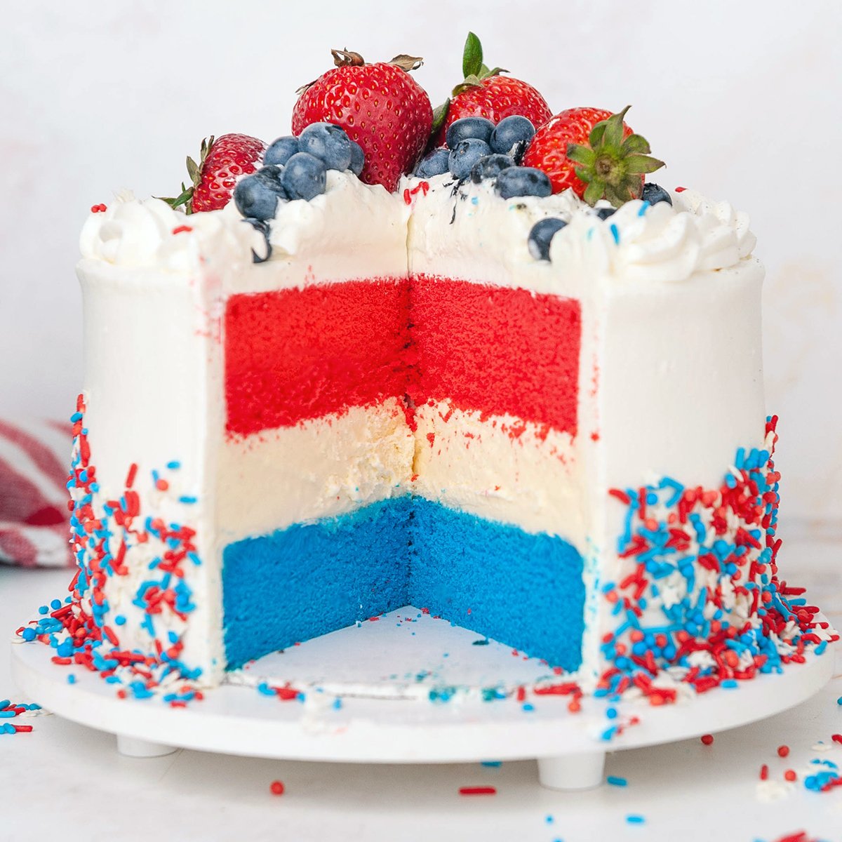 close up of red white and blue cake with slice taken out of the front