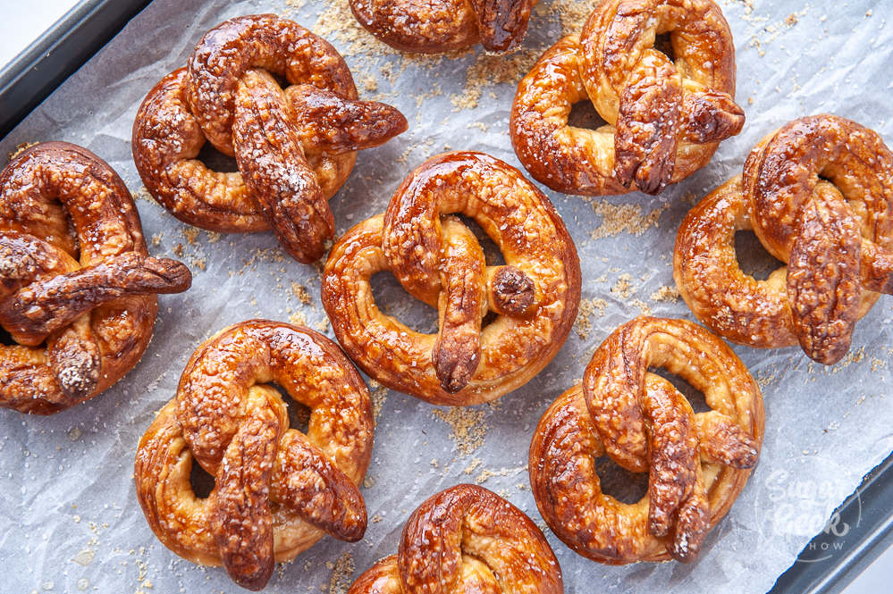 freshly baked pretzels on baking sheet with white parchment paper