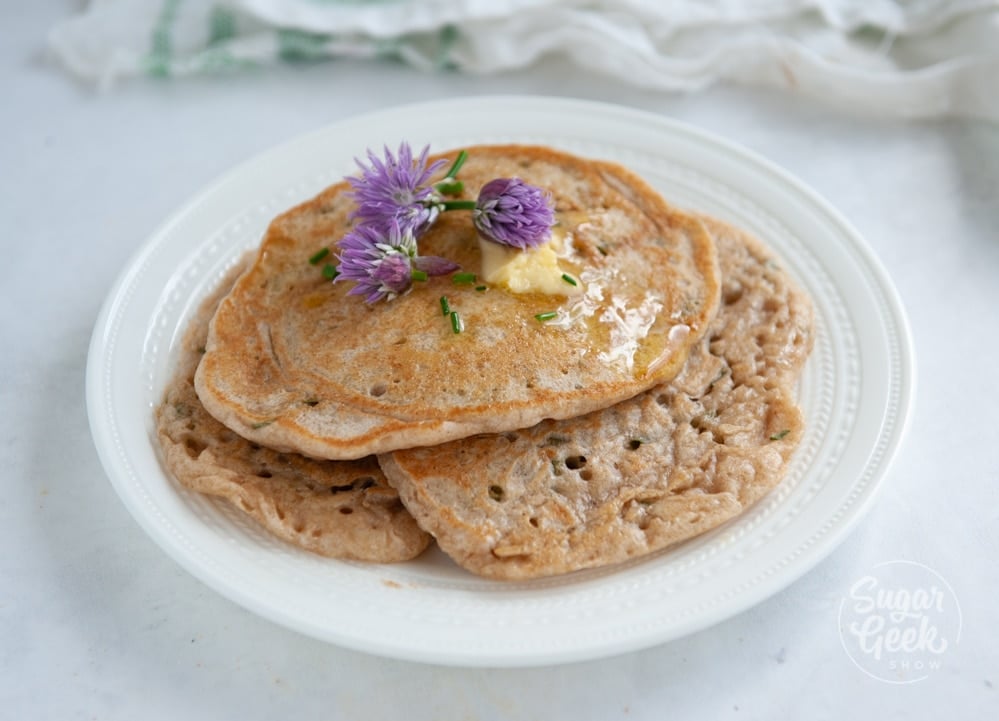 sourdough pikelets with chives on a white plate