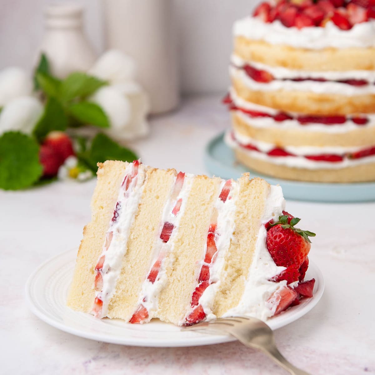 closeup of strawberry shortcake slice on a white plate