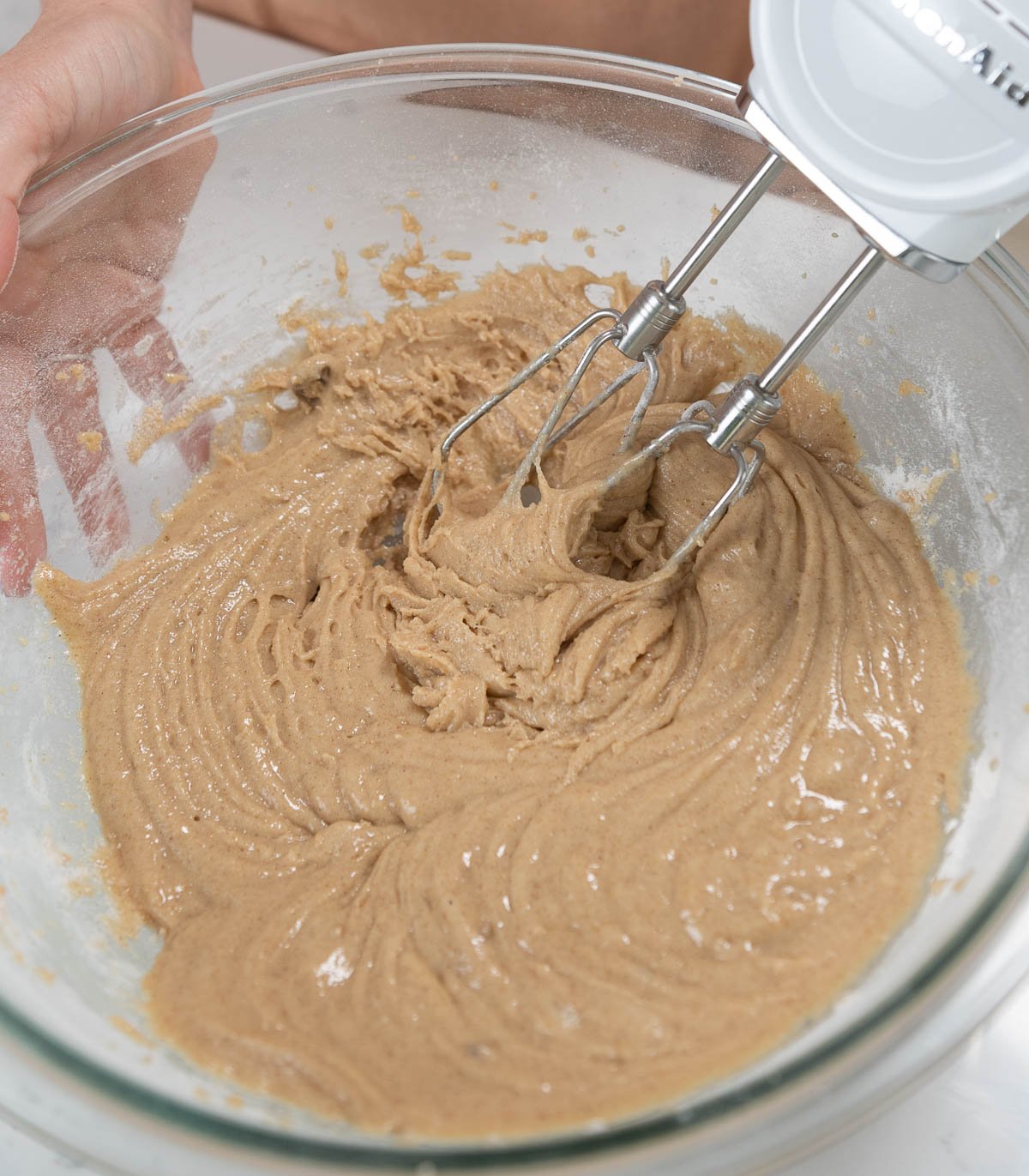 mixing texas sheet cake batter in a clear mixing bowl