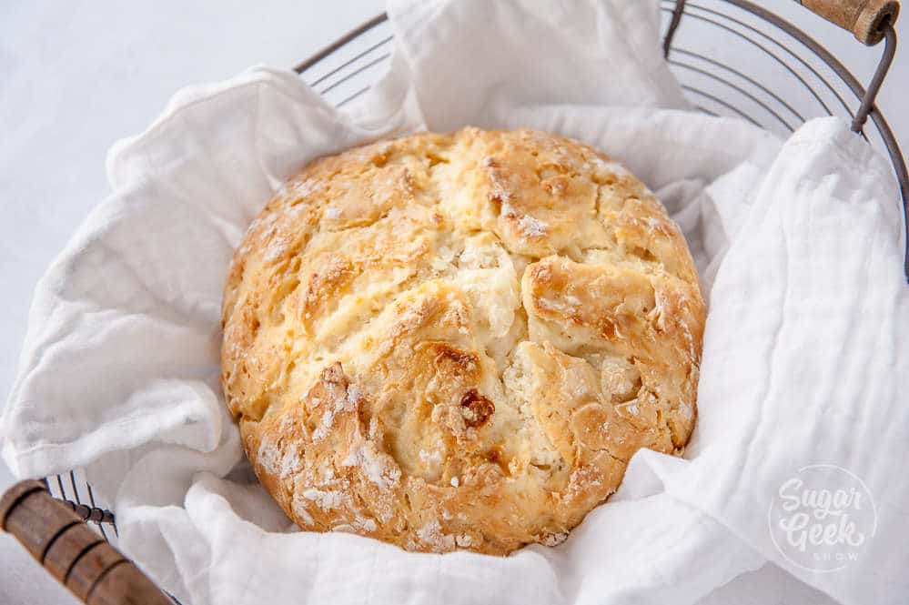 traditional irish soda bread wrapped in white fabric in a basket