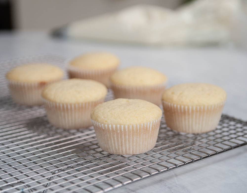 closeup of vanilla cupcakes on a cooling rack