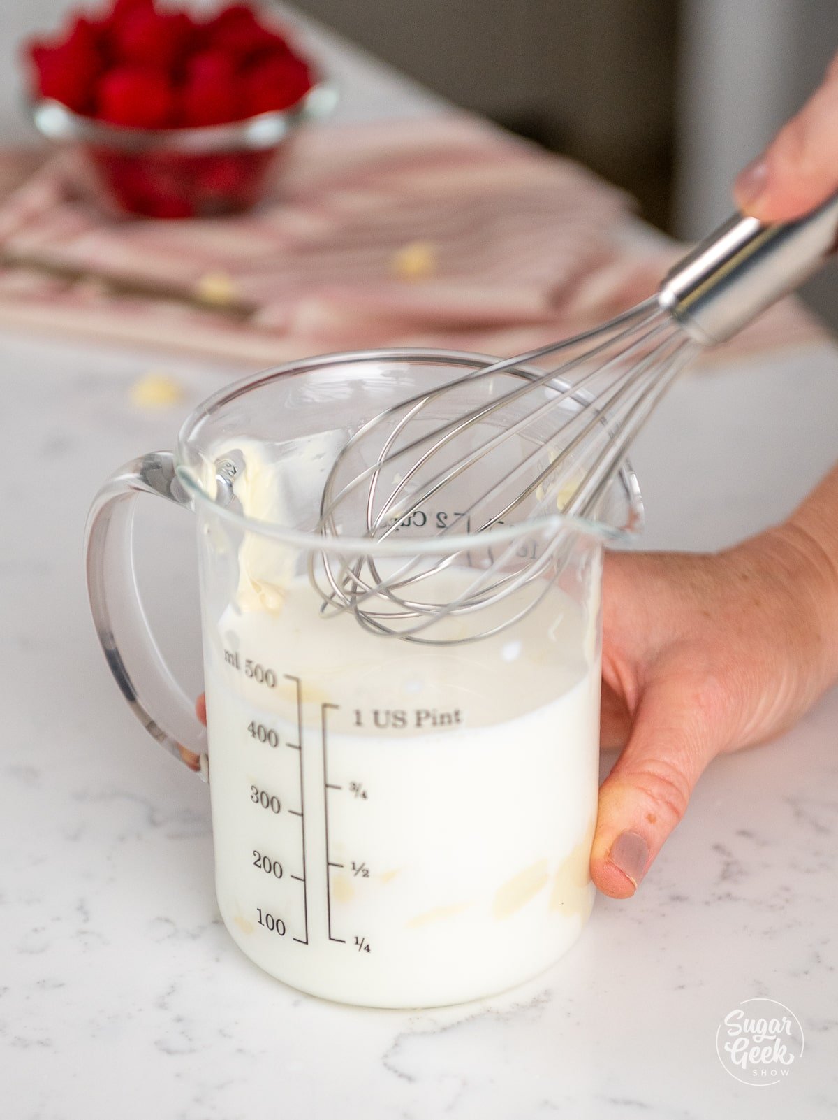 whisk mixing together container of milk