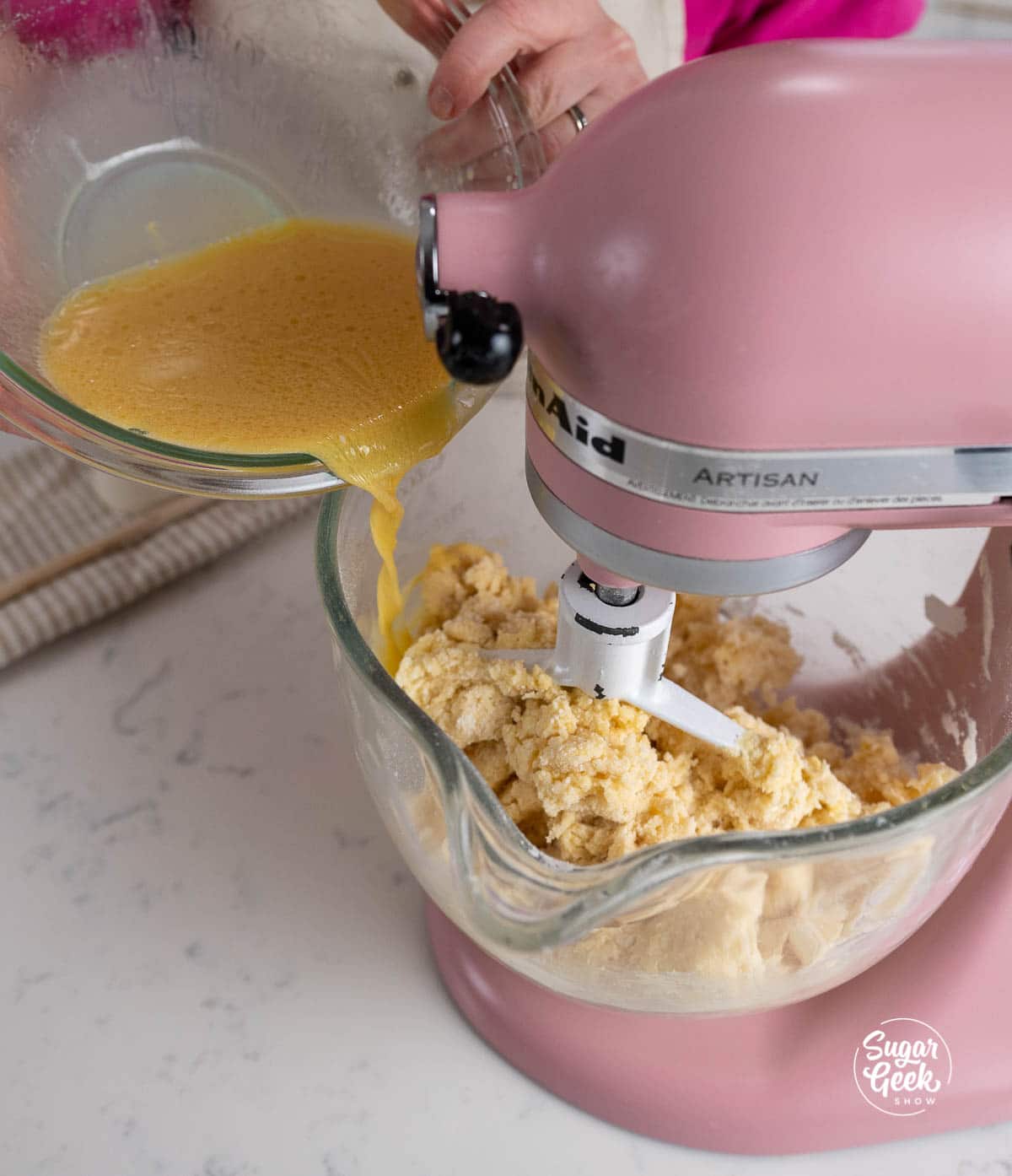 adding liquid ingredients to a stand mixer bowl