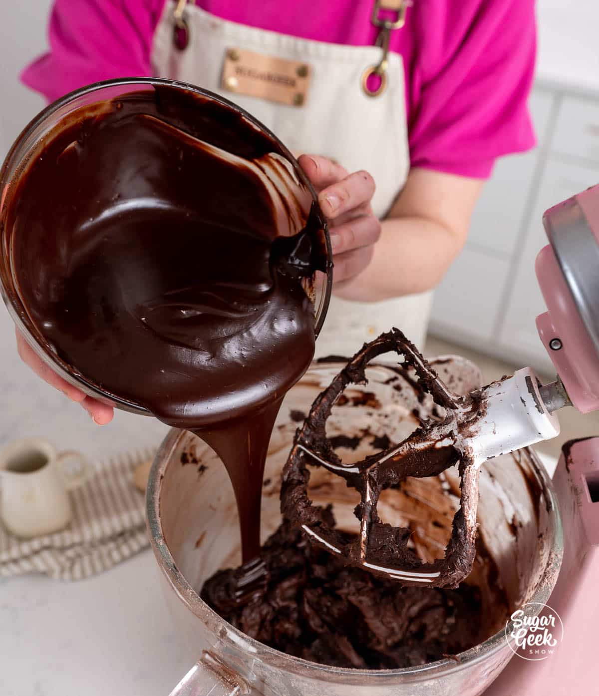 pouring a bowl of chocolate to a bowl of frosting