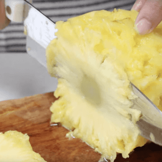 Lay the pineapple on it's side and cut very thin slices with a sharp knife